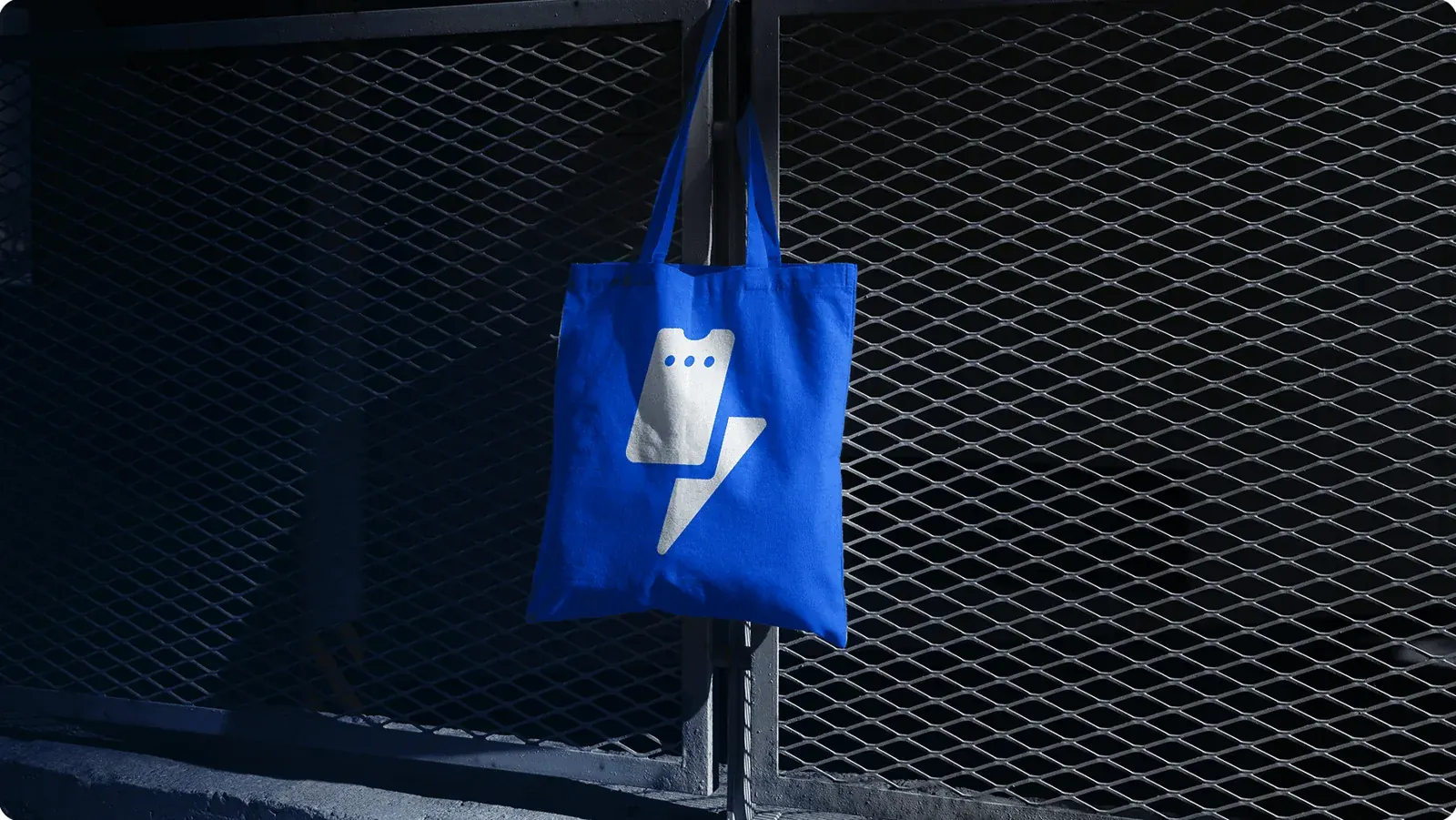 A TICKIZ tote bag hanging on a fence