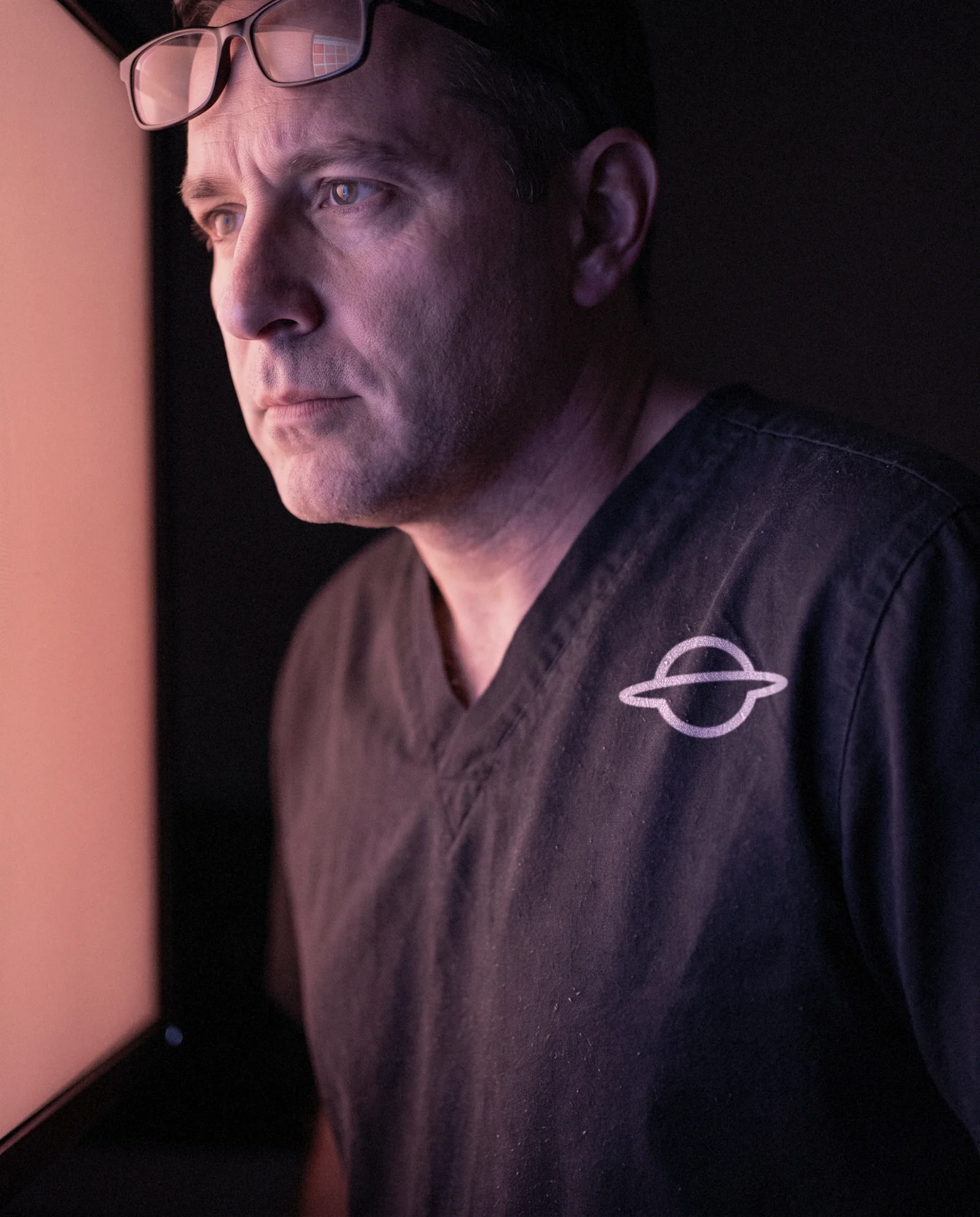 A pathologist in Amoeba scrubs in warm light