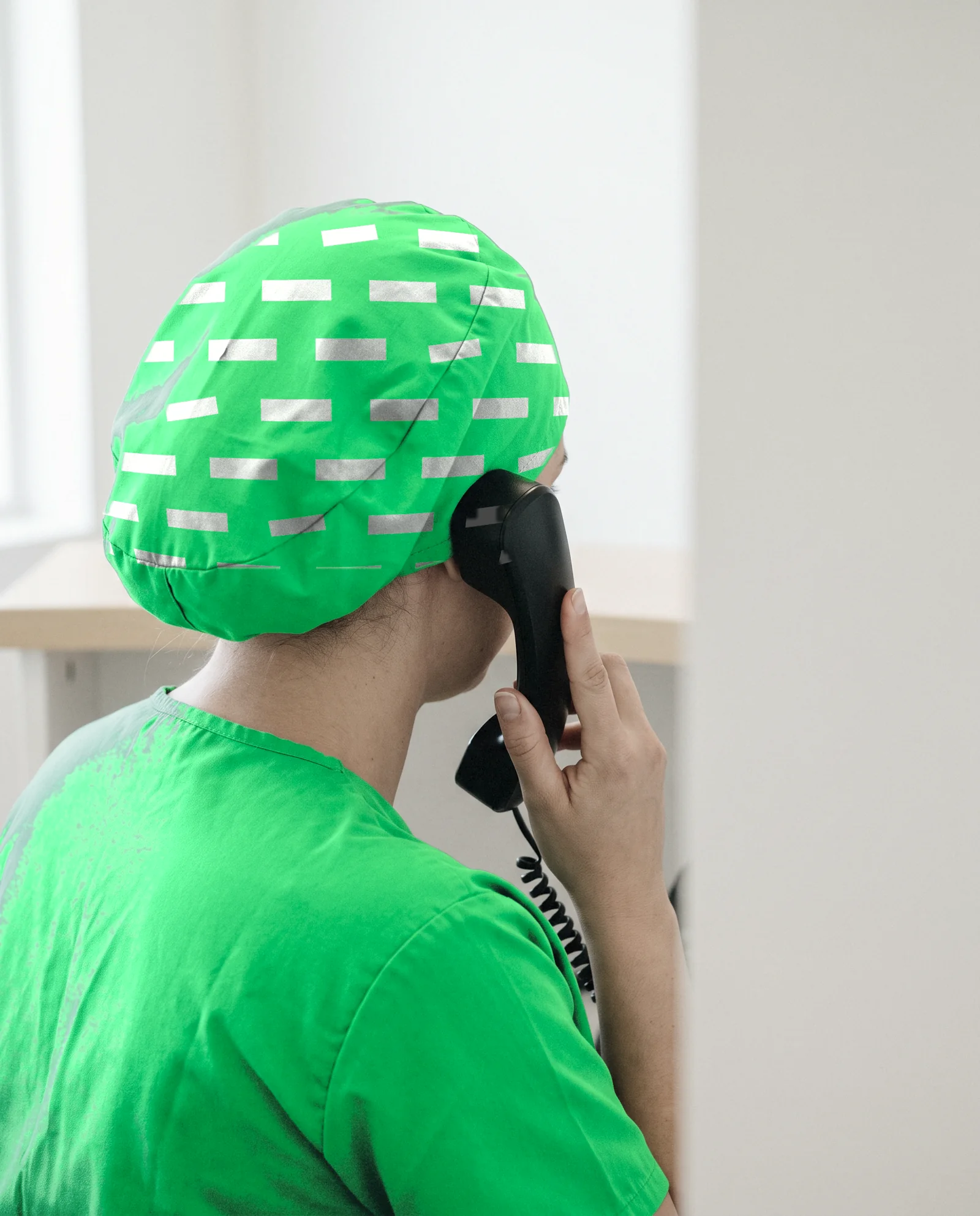 A green scrub cap printed with the Firstring pattern