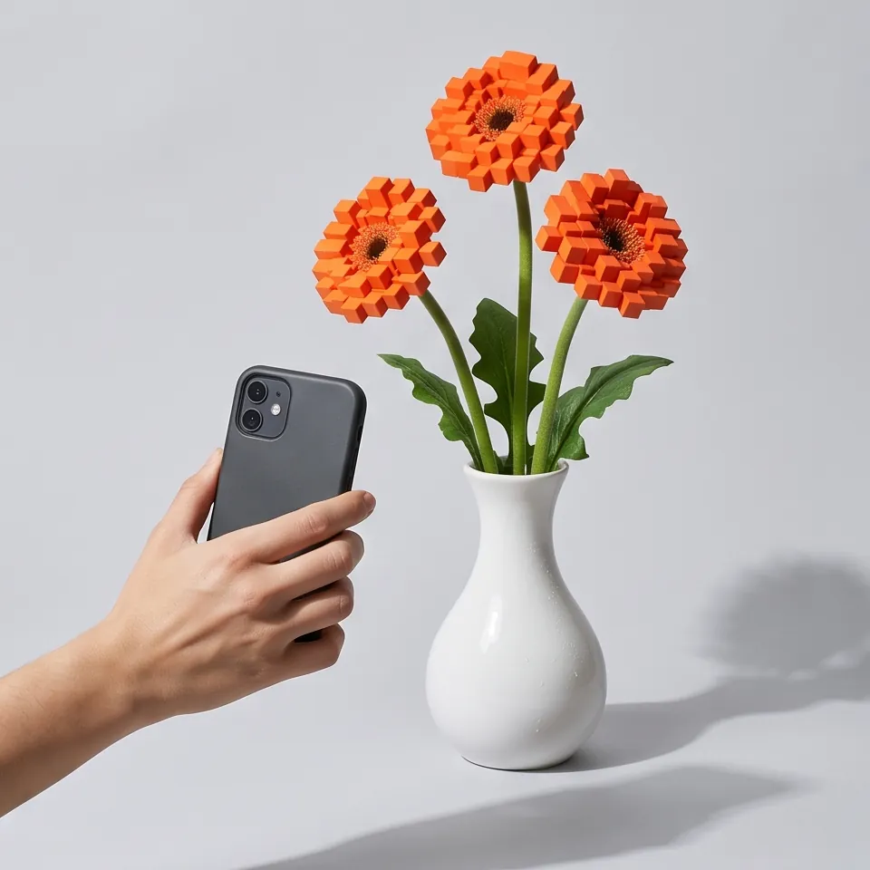 Gerberas in a white vase with cube flower heads, a hand holding a phone beside them