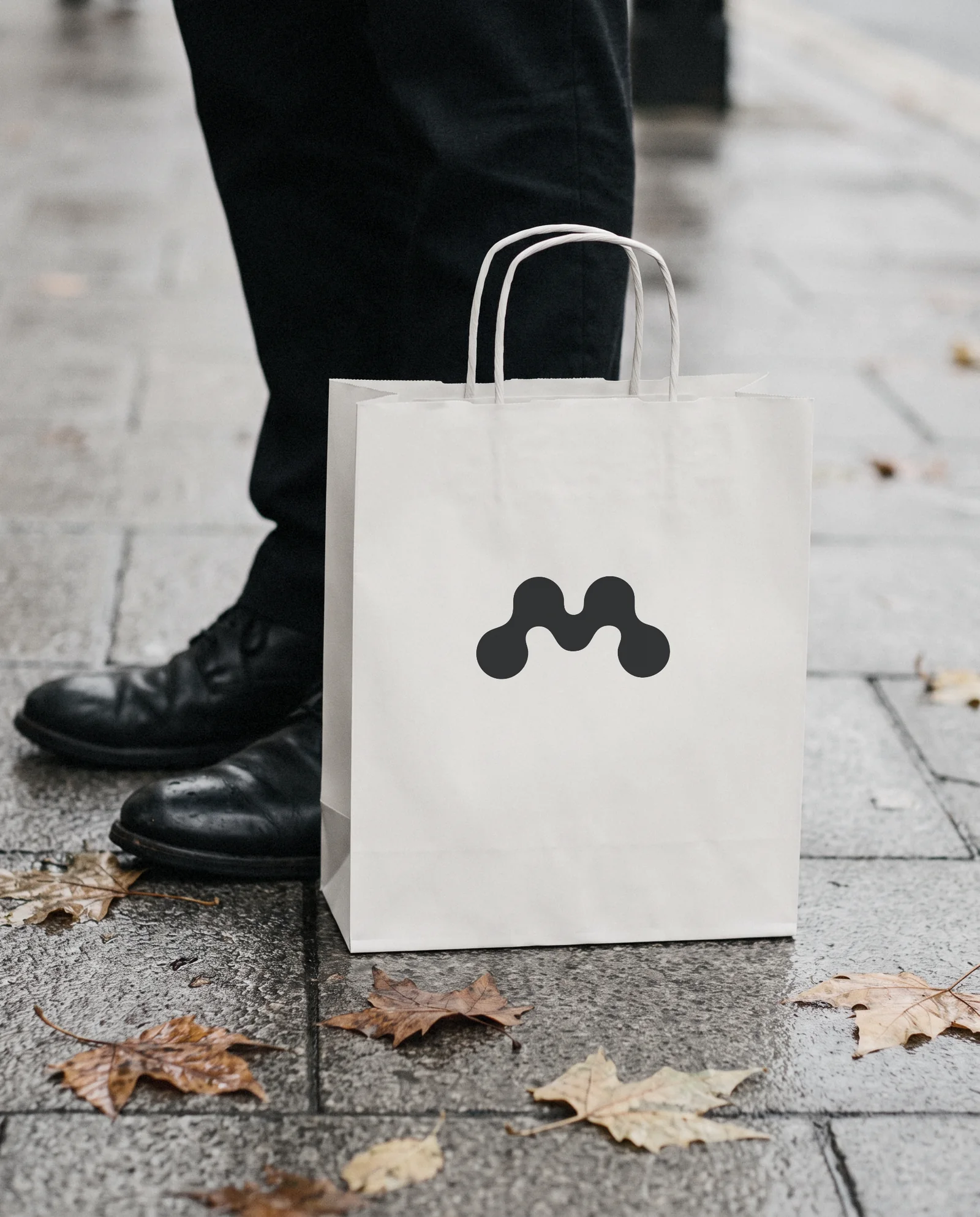 A white Mote paper bag on a wet pavement