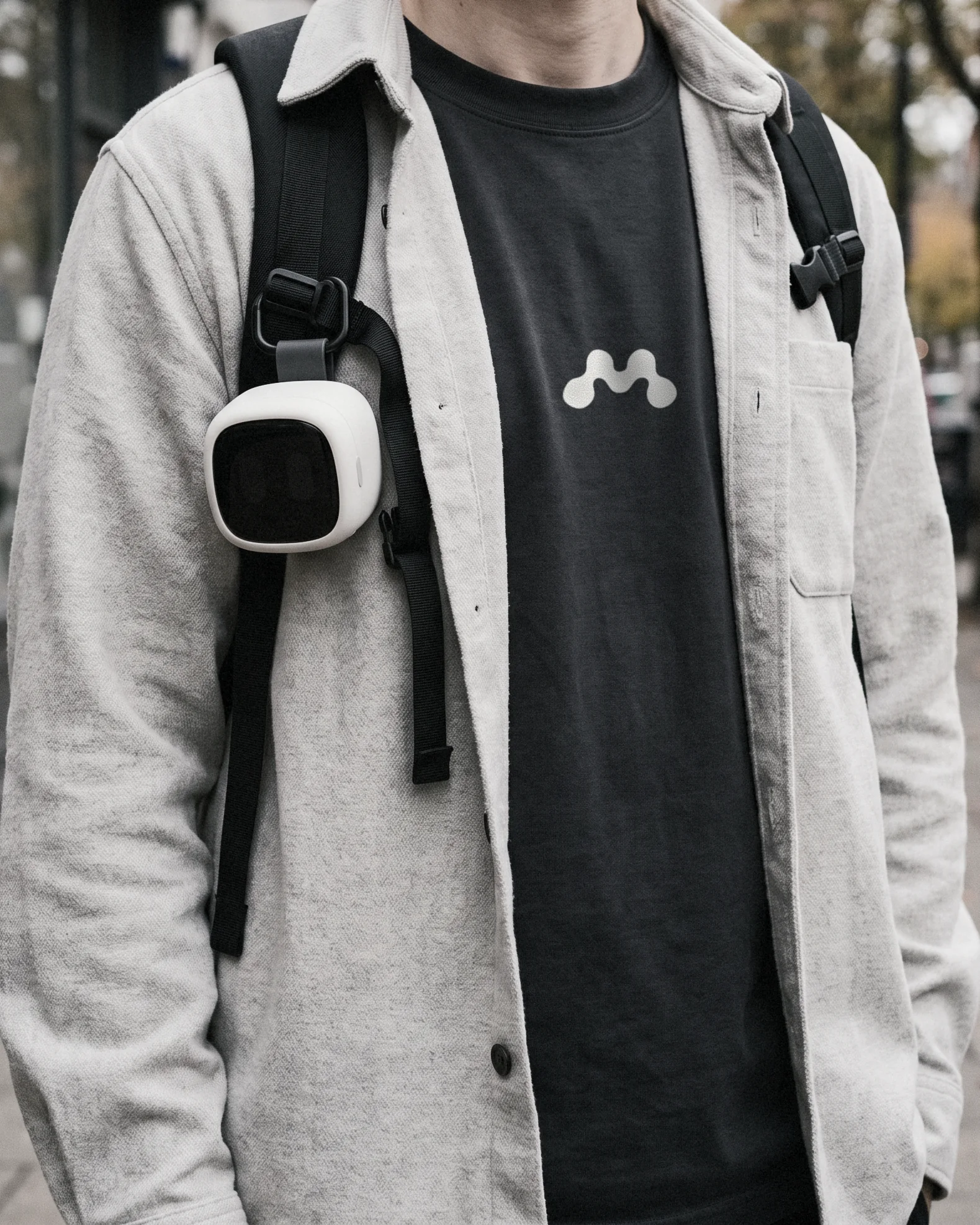 A Mote tee with the dotted M on the chest, the clip camera on the bag strap