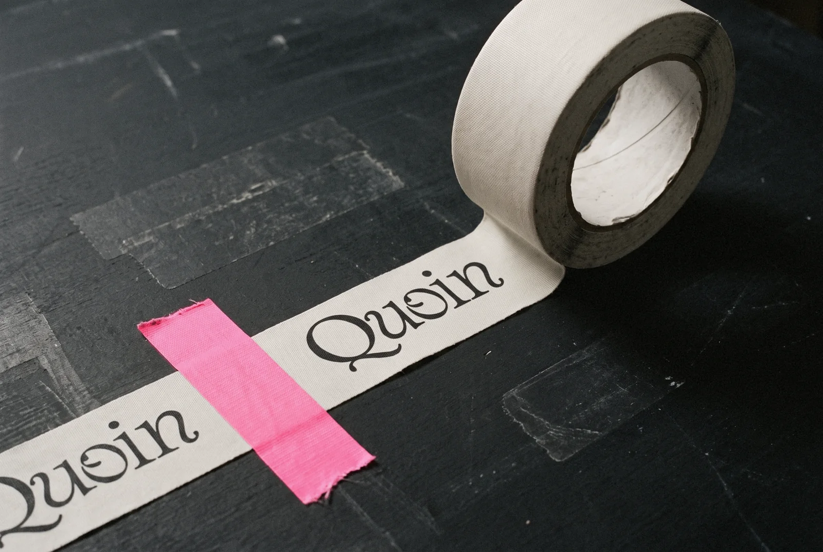 Quoin printed on a roll of bone tape with a pink strip