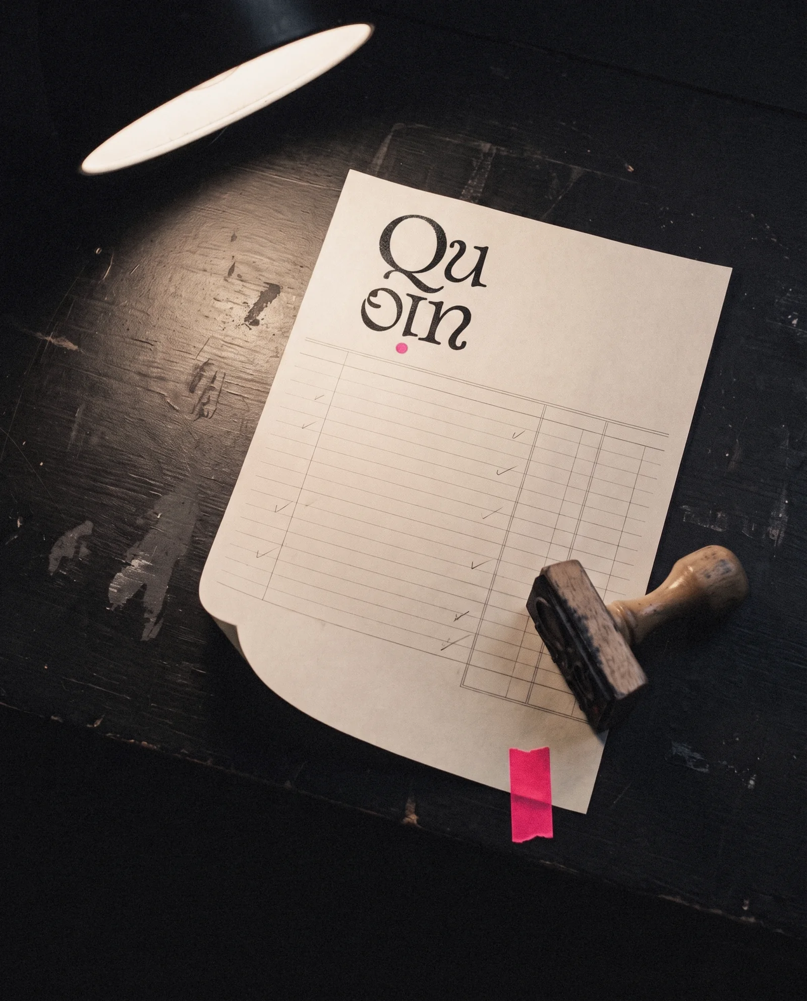 The Quoin mark rubber-stamped on an invoice held for sign-off